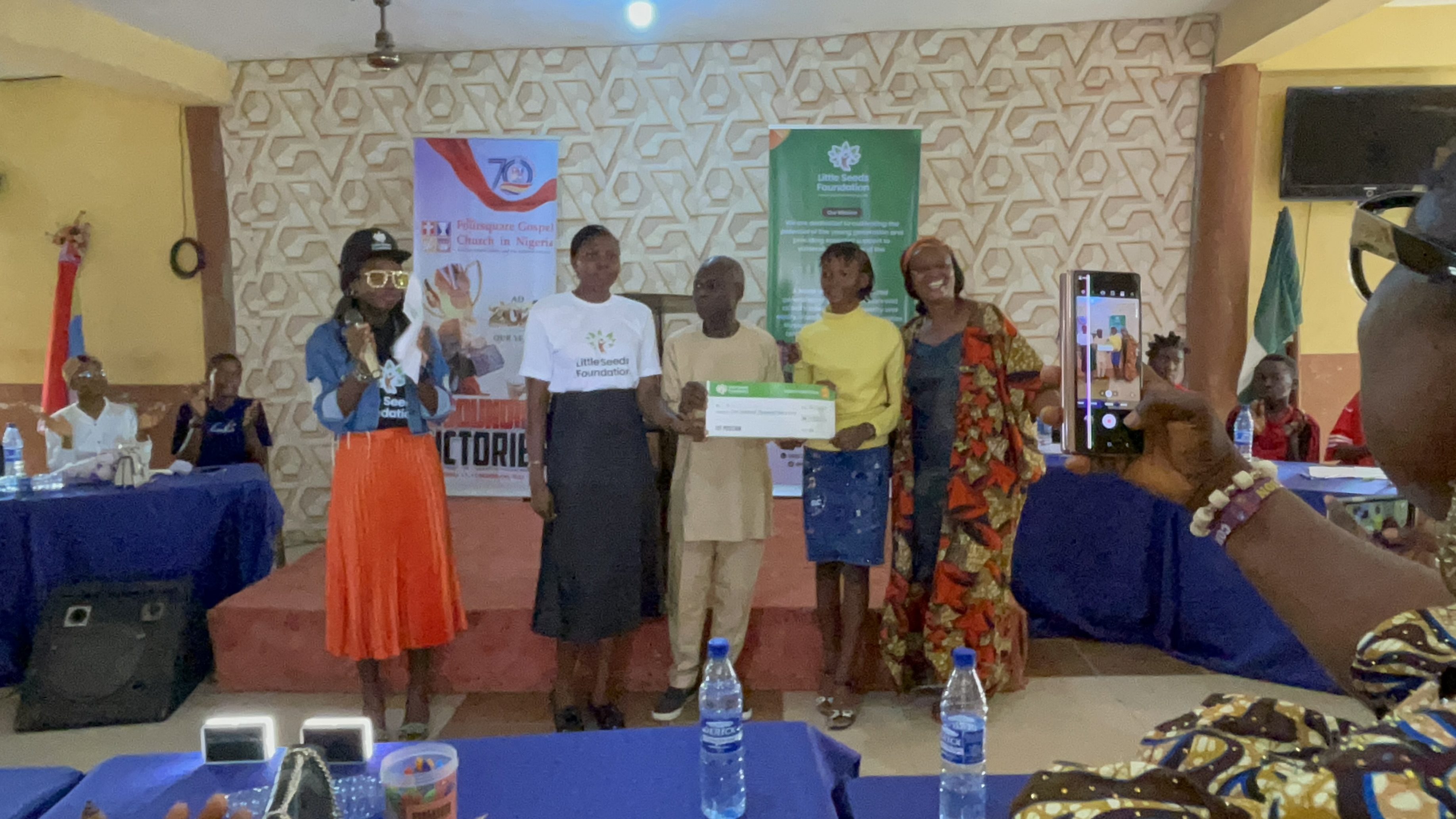 A prize presented on stage as supporters cheer at the inter-church debate