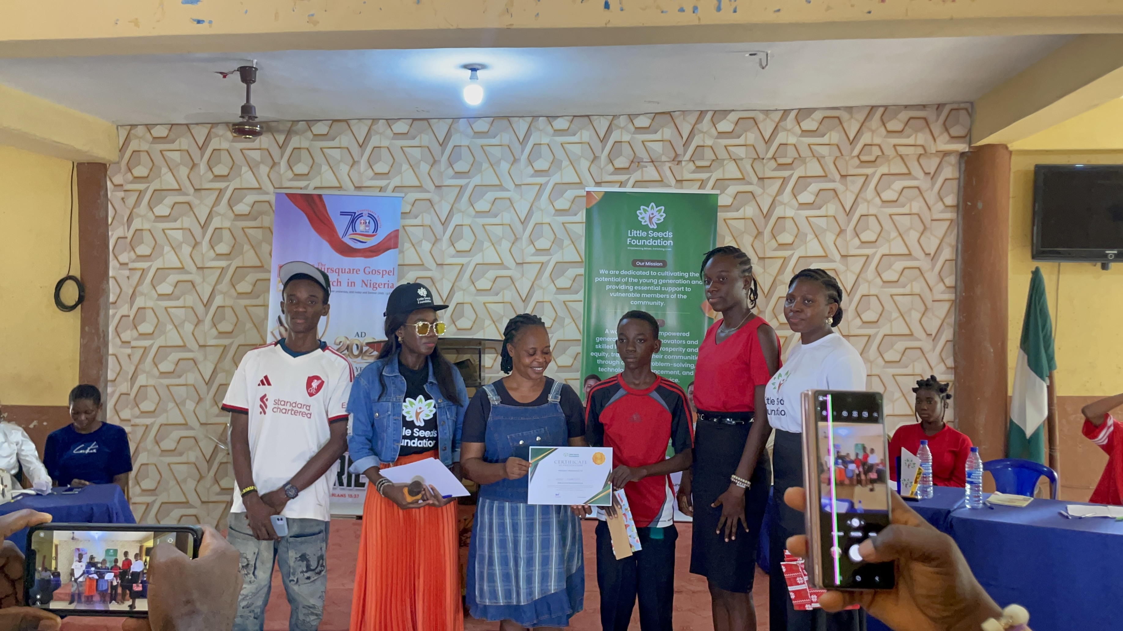 A debater receives a certificate, joined by family at the inter-church debate